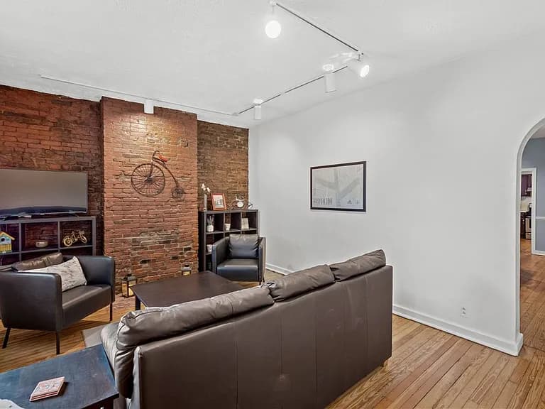 Interior listing photo showing the exposed brick feature wall and seating area